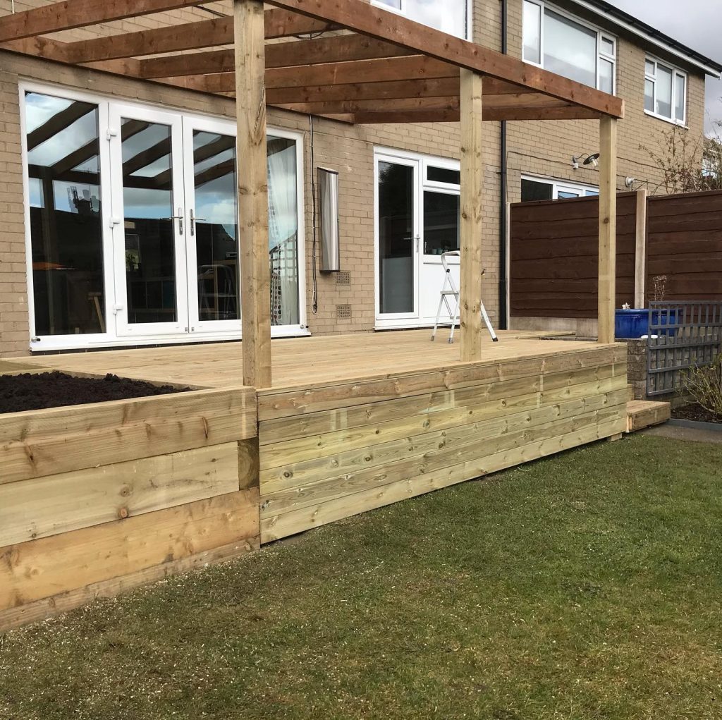 Timber pergola and raised sleeper deck built beside a modern house