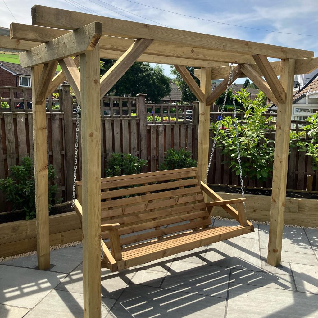 Timber garden pergola with an integrated bench and paved seating area