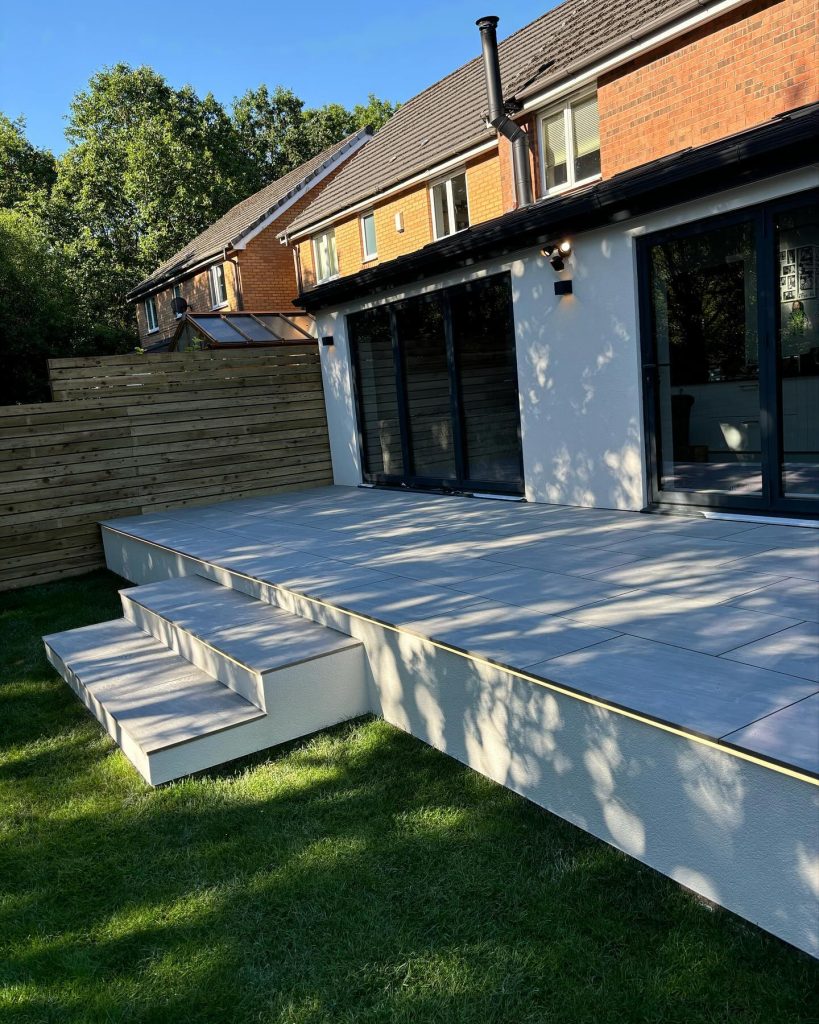 Raised patio finished with large-format grey porcelain paving