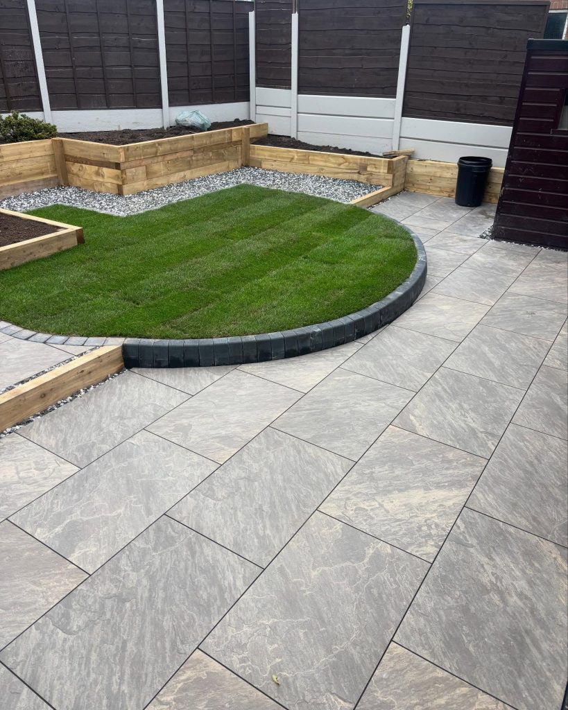 Curved lawn, paved patio and raised timber planters in a completed garden