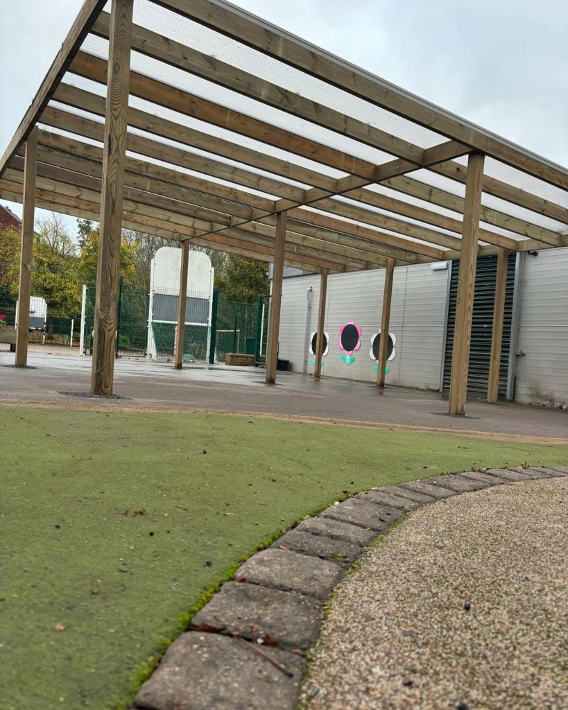 Large timber-covered outdoor shelter with a polycarbonate roof