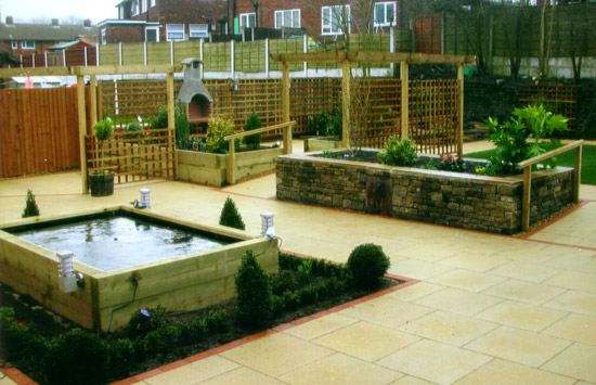 Landscaped communal garden at a care home with lawns, paths, raised beds and clipped shrubs